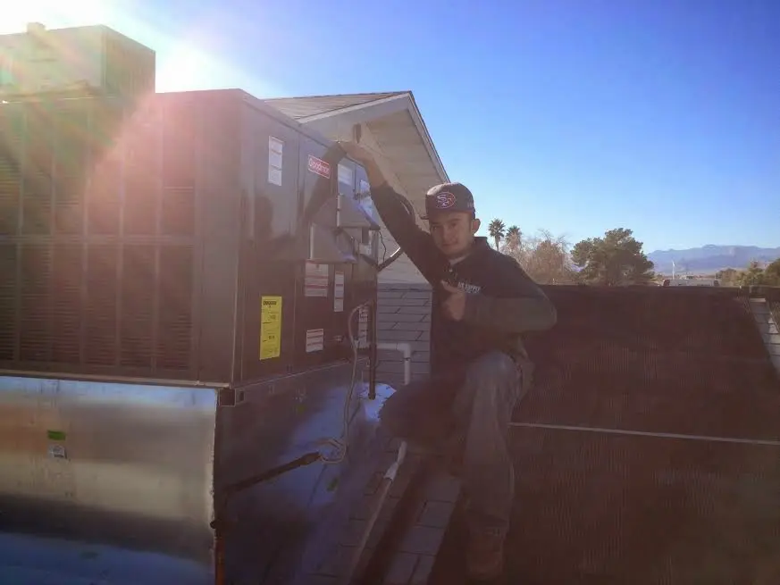 HVAC technician performing Air Duct Repair on a rooftop unit in Cambridge